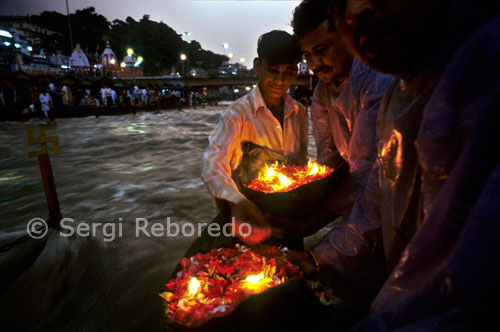 INDIA CROSSING THE RIVER GANGES Haridwar is famous for its Ganga Arati; worship of Ganga Maiya; held nightly at Har-ki-pari Ghat. Every night; (except for a short period during the summer when the ghat is cleaned & repaired; ) thousands of devotees & pilgrims gather about an hour before sunset. As the sky begins to darken; devotees bathe & offer diyas (leaf-boats with camphor flames) to the River. Chants are played over loudspeakers; such as Sri Hanuman Chalisa & others; as the spiritual energy continues to grow. Then; just as darkness descends; numerous priests; (I have counted as many as 16); come out from the ancient Ganga Mandir carrying huge flaming ghee lamps. It appears as though they are carrying campfires in their hands! The Ganga arati song is then played over the loudspeakers while all the thousands of pilgrims join in the singing & the priests wave their flaming lamps to Ma Ganga; swooping down to just skim the surface of the water: "Om Jai Ganga Mata / Maiya Jai Gange Mata!" The spiritual vibration & upliftment of consciousness one feels simply is beyond description. You will just have to go there & feel it for yourself! In just a few minutes the Arati is over & everyone dispersses -- until the next night.