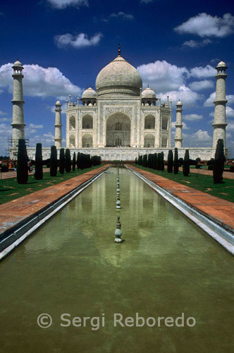 INDIA CRUZANDO EL RIO GANGES vista Taj Mahal delante. El Taj Mahal es el ejemplo mejor y más sofisticado de la arquitectura mogol. Sus orígenes se encuentran en las circunstancias en movimiento de su comisión y la cultura y la historia de un imperio islámico imperio mogol de gran parte de India.The angustiado emperador mogol Shah Jahan encargó el mausoleo a la muerte de su esposa favorita, Mumtaz Mahal. Hoy en día es uno de los edificios más famosos y reconocibles en el mundo y mientras que el mausoleo de mármol blanco con cúpula es la parte más conocida del monumento, el Taj Mahal es un extenso complejo de edificios y jardines que se extiende sobre 22,44 hectáreas e incluye tumbas filial , La infraestructura de obras sanitarias, el pequeño pueblo de 'Taj Ganji "y un " jardín de luz de la luna' al norte del río. La construcción comenzó en 1632 AD, (1041 AH), en la orilla sur del río Yamuna en Agra, ya era sustancialmente completa para 1648 AD (1058 AH). El diseño fue concebido como una réplica tanto terrenal de la casa de Mumtaz en el paraíso y un instrumento de propaganda para el emperador.