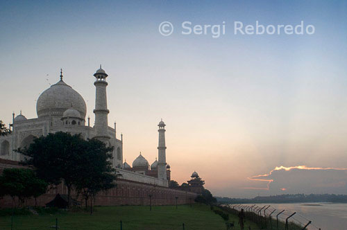 INDIA CRUZANDO EL RIO GANGES El complejo del Taj Mahal está limitada en tres lados por paredes almenadas de piedra arenisca roja, con el lado del río, mirando hacia la izquierda abierta. Taj Mahal es considerado como una de las ocho maravillas del mundo, y algunos historiadores occidentales han señalado que su belleza arquitectónica no ha sido superado. El Taj es el monumento más hermoso construido por los mogoles, los gobernantes musulmanes de la India. Taj Mahal está construido enteramente de mármol blanco. Su belleza arquitectónica está más allá de una descripción adecuada, sobre todo al amanecer y al atardecer. El Taj parece brillar a la luz de la luna llena. En una mañana de niebla, los visitantes experimentar el Taj como si estuviera suspendido cuando se ve desde el otro lado del río Jamuna. El Taj Mahal fue construido por un musulmán, el emperador Shah Jahan (fallecido en 1666 dC) en la memoria de su querida esposa y la reina Mumtaz Mahal en Agra, India. Se trata de una "elegía en mármol" o algunos dicen que la expresión de un "sueño". Taj Mahal (es decir, Palacio de la Corona) es un mausoleo que alberga la tumba de la reina Mumtaz Mahal en la cámara baja. La tumba de Shah Jahan se añadió más tarde. nombre real de la reina fue Arjumand Banu. En la tradición de los mogoles, damas importantes de la familia real se les dio otro nombre en su matrimonio o en algún otro evento importante en sus vidas, y que el nuevo nombre fue utilizado comúnmente por el público. el verdadero nombre de Shah Jahan fue Shahab-ud-Din, y era conocido como el Príncipe Khurram antes de ascender al trono en 1628. El Taj Mahal fue construido en un período de veintidós años, que emplea veinte mil trabajadores. Fue terminado en 1648 la CE a un costo de 32 millones de rupias. Los documentos de construcción muestran que su arquitecto principal fue Ustad Isa ", el reconocido arquitecto islámica de su tiempo. Los documentos contienen nombres de los empleados y el inventario de materiales de construcción y su origen. artesanos expertos de Delhi; Qannauj, Lahore, Multan y fueron empleados. Además, muchos renombrados artesanos musulmanes de Bagdad, Shiraz y Bujara trabajado en muchas tareas especializadas.