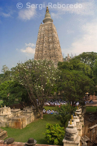 INDIA CROSSING THE RIVER GANGES Mahabodhi Temple In Bodhgaya. The Mahabodhi Temple Complex is one of the four holy sites related to the life of the Lord Buddha; and particularly to the attainment of Enlightenment. The first temple was built by Emperor Asoka in the 3rd century B.C.; and the present temple dates from the 5th or 6th centuries. It is one of the earliest Buddhist temples built entirely in brick; still standing in India; from the late Gupta period. The Mahabodhi Temple; one of the few surviving examples of early brick structures in India; has had significant influence in the development of architecture over the centuries. balustrades; and the memorial column. The present temple is one of the earliest and most imposing structures built entirely from brick in the late Gupta period. The sculpted stone balustrades are an outstanding early example of sculptural reliefs in stone. The Temple Complex has direct associations with the life of the Lord Buddha (566-486 BC) as the place where in 531 BC he attained the supreme and perfect insight while seated under the Bodhi Tree. It provides exceptional records for the events associated with his life and for subsequent worship; particularly since Emperor Asoka made a pilgrimage to this spot around 260 BC and built the first temple at the site of the Bodhi Tree. The Mahabodhi Temple Complex is located in the very heart of the city of Bodh Gaya. The site consists of the main temple and six sacred places within an enclosed area; and a seventh one; the Lotus Pond; just outside the enclosure to the south. The most important of the sacred places is the giant Bodhi Tree (Ficus religiosa ). This tree is to the west of the main temple and is supposed to be a direct descendant of the original Bodhi Tree under which the Buddha spent his First Week and where he had his enlightenment. To the north of the central path; on a raised area; is the Animeshlochan Chaitya (prayer hall) where the Buddha is believed to have spent the Second Week. The Buddha spent the Third Week walking 18 paces back and forth in an area called Ratnachakrama (Jewelled Ambulatory); which lies near the north wall of the main temple. The spot where he spent the Fourth Week is Ratnaghar Chaitya; located to the north-east near the enclosure wall. Immediately after the steps of the east entrance on the central path there is a pillar which marks the site of the Ajapala Nigrodh Tree; under which Buddha meditated during his Fifth Week; answering the queries of Brahmins. He spent the Sixth Week next to the Lotus Pond to the south of the enclosure; and the Seventh Week under the Rajyatana Tree currently marked by a tree. The Main Temple is built in the classical style of Indian temple architecture. It has a low basement with mouldings decorated with honeysuckle and geese design. Above this is a series of niches containing images of the Buddha. Further above there are mouldings and chaitya niches; and then the curvilinear shikhara or tower of the temple surmounted by amalaka and kalasha (architectural features in the tradition of Indian temples). At the four corners of the parapet of the temple are four statues of the Buddha in small shrine chambers. A small tower is built above each of these shrines. The temple faces east and consists of a small forecourt in the east with niches on either side containing statues of the Buddha. Next to the Bodhi Tree there is a place with a Buddha statue that stands on part of the polished sandstone Vajrasana (Diamond Throne); originally installed by Emperor Asoka to mark the spot where the Buddha sat and meditated. Granite pillars were added to enlarge the area in the 5th-6th centuries BC. Further up the central path towards the main temple to the south is a small shrine with a standing Buddha in the back and with the footprints (Padas ) of the Buddha carved on black stone; dating from the 3rd century BC; when Emperor Asoka declared Buddhism to be the official religion of the state. Further on the path towards the main temple is a building housing several statues of Buddha and Bodhisattvas. Opposite is a memorial to a Hindu Mahant who had lived on this site during the 15th and 16th centuries. To the south of the pathway is a cluster of votive stupas built by kings; princes; noblemen and lay people.