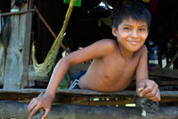 Boy in a House In The Ngobe Bugle Indian Village Of Salt Creek Near Bocas Del Toro Panama. Salt Creek (in Spanish: Quebrada Sal) is a Ngöbe Buglé village located on the southeastern end of Bastimentos island, in the Bocas del Toro Archipelago, Province and District of Panama.  The community consists of about 60 houses, an elementary school, handcrafts and general stores. The villagers depend mostly on their canoes for fishing and transportation although the village is slowly developing together with the whole archipelago. 