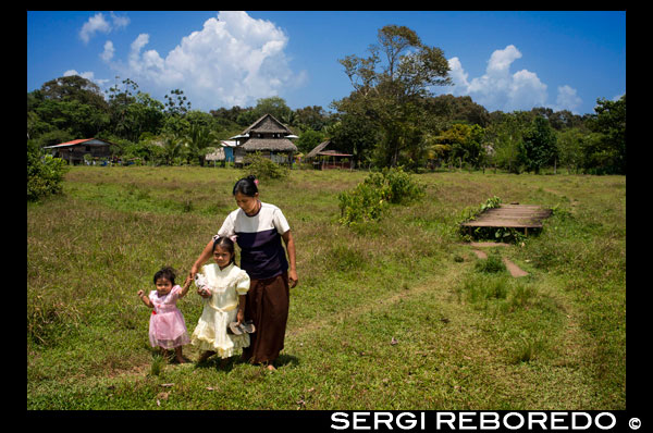 Family and Houses In The Ngobe Bugle Indian Village Of Salt Creek Near Bocas Del Toro Panama. Salt Creek (in Spanish: Quebrada Sal) is a Ngöbe Buglé village located on the southeastern end of Bastimentos island, in the Bocas del Toro Archipelago, Province and District of Panama.  The community consists of about 60 houses, an elementary school, handcrafts and general stores. The villagers depend mostly on their canoes for fishing and transportation although the village is slowly developing together with the whole archipelago.  Between the Caribbean Sea, with its mangroves, coral reefs, and paradisiacal islands, and the dense humid tropical forest of Bastimentos Island, lies the Ngobe community known as Salt Creek (Quebrada Sal).  Here, the local organization ALIATUR (Salt Creek Tourism Alliance) has created a project so that visitors to the Bocas del Toro Archipelago can get to know the culture of this indigenous community, its artisan crafts, its dances, and its stories.  Actions taken to promote environmental or social sustainability Four hiking trails in the surrounding forests allow the tourist to appreciate the rich fauna and flora of the region. Lodging and typical local food are offered for whoever wishes to visit for one or more days in the community.  In case this isn´t enough, the community´s proximity to the Bastimentos National Marine Park allows tourists to pay a quick visit to the marvelous Zapatilla Cays and to enjoy its beaches, coral reefs, and trail.