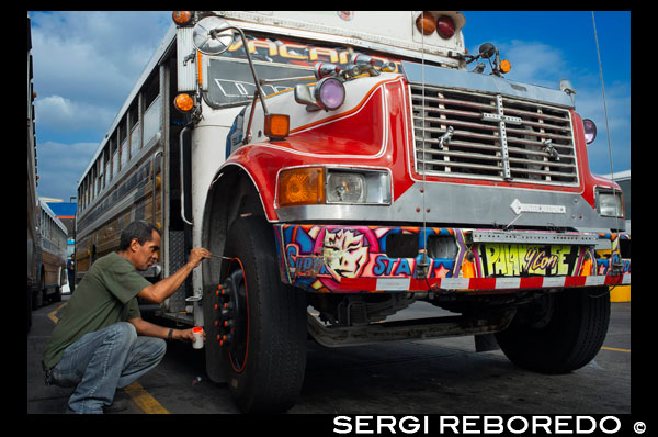 Decorating a BUS RED DEVIL DIABLO ROJO PAINTED BUS PANAMA CITY REPUBLIC OF PANAMA. Albrok bus station terminal. Panama. Here comes the Diablo Rojo, the Red Devil bus blasting its air horn and fishtailing around a fellow “demon” just in time to claim Irma Betancourt and other morning commuters. Suffice it to say the Red Devils earn their name. “They are crazy,” said Ms. Betancourt, 33, a housekeeper at a downtown hotel, boarding on a main boulevard. “We all know that. All they care about is getting the fare. So many times we have almost hit somebody.”  Wandering around Panama City it’s hard to miss these crazy fuckin buses rolling around the city. Converted school buses are used as inexpensive public transportation. Each bus in the city is individually decorated which makes an interesting catch whenever rolling around. The average cost to ride one of these buses is 25 cents!  “Almost” may make her bus one of the lucky ones, as they are known to have taken more than a few souls for the sake of a pickup.  Her bus on a recent morning is like hundreds of others, a converted, cast-off American school bus ablaze with color, usually heavy on the red.  As if painted by a graffiti artist addicted to action movies and sports, they often boast fanciful, dreamy scenes, including, improbably, a looming Dumbledore from the Harry Potter movies glaring at Ms. Betancourt as she climbs aboard.  Reggaetón, salsa and other bass-heavy music concuss the air, to attract riders to the privately owned buses. Growling mufflers contribute to the soundtrack of the streets. And no self-respecting grille lacks a wild string of Christmas lights.  Typical fare: 25 cents.  “They evolved into the most visually dominant aspect of Panama City,” said Peter Szok, a professor at Texas Christian University in Fort Worth who has studied the buses and the folk art of Panama.  It is a tradition elsewhere in the region as well, in other Panama cities as well as in countries like Suriname, where the buses are adorned with politically tinged portraits of heroes and outlaws. But here, at least, the ride is coming to an end.  The buses, many of them retired from Florida schools, have been the backbone of public transit here for more than four decades, with the tradition of decorating vehicles used for public transportation going back even further. Mr. Szok traces the art form to a desire to reflect Latin music styles and an idealized life.  Panama City, however, is rapidly modernizing, with a towering skyline and sprawling shopping malls that promoters hope will put it on the map as another Singapore.  With that has come a push for order. A subway is being dug. Roadways are being built or planned. The Red Devils, owned and operated by their drivers with no real set schedule, are being phased out in favor of something decidedly more vanilla and benign, a Metro Bus system with generic boxy white vehicles familiar in any cities. The only dash of a color is an orange slash.  “Safe, comfortable, reliable,” is the slogan. There is even a route map.  President Ricardo Martinelli, whose administration has championed the new system, has pointed to the new buses as a sign of progress, blaming the Red Devils for accidents and accusing them of unreliable service.  “They will race from one end of the city to the other, killing people, killing themselves,” he said in a speech in Washington in April. “Yeah, a lot of people were killed.”  But the Metro Buses, too, are drawing complaints, mainly for slow service. The 25-cent fare on most routes is expected to rise to 45 cents next year, and is already drawing grimaces. Some have taken to calling them the Diablos Blancos, the White Devils.  “Hey! The line starts back there,” several people shouted at one crowded downtown Metro Bus stop as their ride finally arrived in a downpour.  “Look at this long line and little bus shelter,” said David Polo, 33, who had been waiting for more than 20 minutes. “The new buses may be safer, but they need more of them.”  Panama’s transportation officials said the Red Devils, numbering about 1,200 in recent years, would be gone by the end of this year, but the plan has been delayed more than once as the new system seeks to hire and train drivers.  As the Red Devils disappear — some of them, in the ultimate twist of fate, converted back to school buses, and others dismantled for scrap or sitting in bus boneyards — something a bit unexpected has emerged.  Sympathy for the Red Devils.  The nostalgia ranges from the tongue in cheek — a “Save the Diablo Rojo” YouTube video purports to mourn the end of tourists’ losing their wallets, among other things, on them — to genuine regrets.  “It is a loss of part of our culture,” said Analida Galindo, a co-director of the Diablo Rosso art gallery in the historic Casco Viejo neighborhood. Yes, the gallery name is a play on the Red Devils’ name.  The gallery sells bus doors painted by one of the more prolific Red Devil artists, Oscar Melgar, for $2,500 (no takers yet).  Mr. Szok said the painters were largely self-taught, many of them the sons of West Indian immigrants, though some in later years had gone to art school. They typically charged $2,000 and up to paint the buses, meaning some are a kaleidoscope of images while, in others, the yellow has been barely painted over, depending on the wherewithal of the driver.  “It was a great tradition that people are going to miss,” said one of the painters, Ramón Enrique Hormi, known as Monchi. “Here it is Christmastime, and what am I going to do? I have nothing.”  Some owners, too, have complained that the $25,000 that the government is offering them in compensation for giving up their buses may sound generous but will not carry them very far.  Several drivers said they could not get jobs with Metro Bus because of their poor driving records, though the new system has hired many Red Devil drivers.  Other drivers said they had long held second jobs and would find other work.  “Everything has to come to an end someday,” one driver, Juan Estanciola, said on a recent day outside his modestly painted bus, which is mostly white with purple trim and bears sayings like “Don’t let my presence mess with your mind.”  He spoke at the door of his bus, which had just collided with a taxi on a rainy afternoon.  “It was his fault,” he said. “He cut in front of me. They don’t know how to drive.”