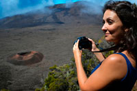 A female tourist photographing one of the boilers of the Piton de la Fournaise volcano. Also known as the 'volcano that smells like vanilla' is located on the French island of Reunion and typically erupts approximately every two years. After several days showing a critical activity, the October 14, 2010 the last eruption occurred violent volcano spit lava and gases expelled into the atmosphere, but fortunately did not end the life of any human. From what is clear is that the island of Reunion, the Indian Ocean's largest-has been shaped over thousands of years by the five volcanoes that watch from above and that this Piton de la Fournaise is the only one still active.