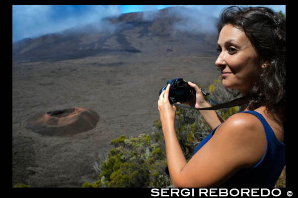 A female tourist photographing one of the boilers of the Piton de la Fournaise volcano. Also known as the 'volcano that smells like vanilla' is located on the French island of Reunion and typically erupts approximately every two years. After several days showing a critical activity, the October 14, 2010 the last eruption occurred violent volcano spit lava and gases expelled into the atmosphere, but fortunately did not end the life of any human. From what is clear is that the island of Reunion, the Indian Ocean's largest-has been shaped over thousands of years by the five volcanoes that watch from above and that this Piton de la Fournaise is the only one still active.