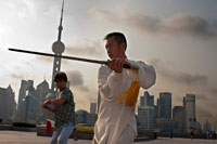 China, Shanghai, morning tai chi exercise on The Bund. Shanghi Bund : Early morning tai chi exercises with swords on the Bund in Shanghai China. The best taichi lessons I've had were from an old guy who practiced outside at 7am every morning. I learned 4 excellent techniques that I still use in my MMA training on a regular basis- a method of catching a kick and throwing your opponent, redirecting a straight punch and countering in the same motion, countering double underhooks with a throw, and escaping a shoulder lock while setting up your own.  It's a really fascinating martial art because every one of those dance like movements represents a simple practical fighting