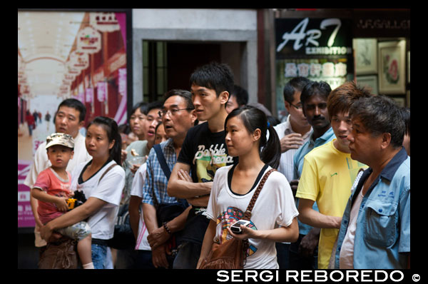 Las personas que ven Shanghai Puppet Show en la ciudad antigua, Shanhai. Los chinos aman a sus hijos, y se limitan, si los habitantes de la ciudad, al menos uno. La multa por violar esta regla es el salario de un año! Estos niños (y abuelos) están participando en el entretenimiento tradicional, la acción visible sólo a través de agujeros para los ojos y por un precio muy bajo, a 3 minutos de 10 yuanes, aproximadamente 1,60 dólares de Estados Unidos. Los visitantes del Wuzhen Shadow Puppet Theater (piy? Ngxì, ???) descubrirán uno de los artes populares más antiguas de China. Sombra Títeres, también conocido como el teatro de sombra, se realiza de tres a cinco jugadores que se presentan obras de teatro y cuentos para una banda sonora de música y los instrumentos chinos tradicionales como el erhu y la flauta. Los personajes son las siluetas de títeres hechos de piel de animal (tradicionalmente buey o piel de oveja) detrás de un telón de fondo brillantemente iluminada. Una vez que una parte fundamental de cualquier festival o celebración, el arte de los títeres de sombras sufrió mucho durante la Revolución Cultural y sólo un puñado de compañías se quedaron todo el país. Los artistas del juego de sombra de Wuzhen son de particular interés y han sido invitados a realizar en Corea, Japón, Singapur, Alemania y otros lugares de todo el mundo.