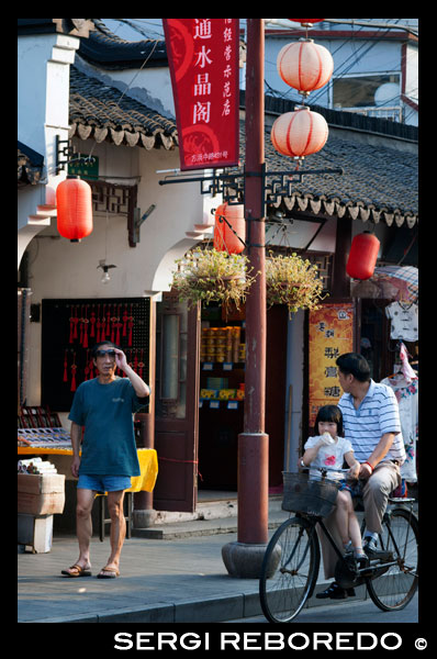 Compres botigues al voltant de petits a la Ciutat Vella, Shanghai, Xina. La ciutat vella de Xangai, Shangh? I L? O Chengxi? Ng, també conegut anteriorment com la ciutat xinesa, és el nucli urbà tradicional de Xangai, Xina. El seu límit es definia per una muralla defensiva. La Ciutat Vella va ser el seient de comtat per l'antic comtat de Xangai. Amb l'adveniment de les concessions estrangeres a Xangai, la ciutat vella es va convertir en només una part del nucli urbà de Xangai, però va continuar en les dècades per ser la seu de l'autoritat de la Xina a Xangai. Les característiques notables inclouen el Temple del Déu de la Ciutat, situat al centre del nucli antic i està connectat amb el Jardí Yuyuan. Amb l'excepció de dues seccions curtes, les parets van ser demolides el 1912, i una àmplia avinguda circular construïda sobre l'antiga muralla i el fossat: la meitat sud es va anomenar el "Zhonghua Road" i la meitat nord de la "Minguo Road" (junts fent dalt "Zhonghua Minguo", o "República de la Xina" en xinès). (La meitat nord va passar a cridar-se "Renmin Road" ("Camí del Poble") en 1950 pel nou govern comunista de Xangai). La Ciutat Vella va ser durant dècades en gran part confrontant amb l'antic Districte Nanshi, que ara és part de districte de Huangpu.