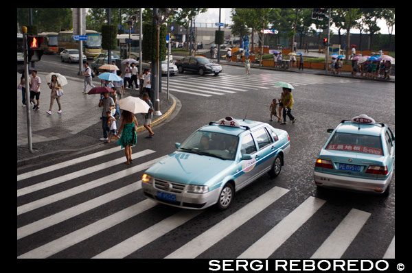 Dos taxis en un dia de pluja a Xangai, Xina. Volkswagen Santana taxis de fàbrica en una aliança d'empreses Xangai amb el cotxe alemany. Xangai compta amb al voltant de 45.000 taxis, operat per més de 150 companyies de taxis. Diverses companyies tenen taxis en els seus propis colors. Hi ha set empreses més populars - Dazhong Taxi Companyia amb els seus cotxes al cel blau; Qiangsheng amb els seus cotxes de color taronja; Blanc Jinjiang; Verd Bashi; Haibo safir blau; Fanlanhong vermell; i Lanse Lianmeng en blau marí. De totes les empreses, es recomanen amb més força Dazhong i Qiangsheng. Prenent taxis a Shanghai és més car que en altres ciutats. Durant el dia, el preu és CNY13 per als tres primers quilòmetres (1,9 milles), un càrrec addicional de CNY2.4 per cada quilòmetre dins dels 10 quilòmetres (6.2 milles) i CNY3.6 per cada quilòmetre després de 10 quilòmetres. A la nit 23: 00-5: 00 del matí següent, la tarifa és de CNY17 per als tres primers quilòmetres, un càrrec addicional de CNY3.1 per cada quilòmetre radi de 10 milles i CNY4.1 per cada quilòmetre després de 10 quilòmetres. Vostè pot negociar sobre els preus en prendre taxis a la nit. Tingueu en compte la càrrega es completarà quan es paga i Xangai Public Transportation Card es pot utilitzar en la majoria dels taxis. Qualsevol cosa raonable, vostè pot presentar una queixa trucant al 021-63232150 o per a l'empresa específica de taxi trucant per telèfon al número que apareix en l'acte.