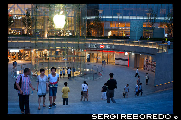 Apple computer store in Lujiazui financial district, in Pudong, in Shanghai, China. View of large modern Apple store in Shanghai China. Apple Store Pudong in front of Shanghai IFC South and North Tower (HSBC building) in Pudong District, Shanghai, China. Shanghai International Finance Centre, usually abbreviated as Shanghai IFC, is a commercial building complex and a shopping centre (branded Shanghai IFC mall) in Shanghai. It incorporates two tower blocks at 249.9 metres (south tower) and 259.9 metres (north tower) housing offices and a hotel, and an 85-metre tall multi-storey building behind and between the two towers.  Shanghai IFC is located in Lujiazui, in Pudong, Shanghai. It occupies a prominent position southeast of the Lujiazui roundabout, diagonally across from the Oriental Pearl Tower and across the road from Super Brand Mall. It is adjacent to Lujiazui Station on Metro Line 2, and can be accessed directly from the underground station via a tunnel.  The south tower of Shanghai IFC and part of the multistorey building was completed in 2009, while the north tower and the rest of the complex was completed in 2010. Work continued for several years afterwards on peripheral aspects of the development, including landscaping and footbridge connections to nearby buildings and Lujiazui Central Park.  The Ritz-Carlton Hotel occupies the south tower, while the north tower houses the current Shanghai headquarters of HSBC in China. Other prominent tenants of the complex include an Apple Store under the sunken forecourt of the building (topped by a cylindrical glass skylight rising from the forecourt), a multi-screen cinema, and a Citysuper supermarket. The remainder of the retail area is largely taken up by upscale chain restaurants and international luxury fashion brands.