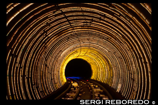 Rastres emmascarats de moviment de llum en un túnel del tren sota el riu Huangpu que uneix el Bund a Pudong, Shanghai, Xina, Àsia. El colorit tren túnel Bund Sightseeing sota el riu Huang Pu connecta Puxi i districtes de Pudong a Xangai Xina Àsia. El Bund Sightseeing Tunnel passa sota el riu Huangpu que connecta la zona de Pudong Districte Bund i Lujiazui. La seva longitud és de 646.7 metres. El Bund Sightseeing Tunnel és gairebé una instal·lació virtual sota el sòl i proporciona una experiència memorable dels efectes multimèdia especials. Els compartiments de turisme tren maglev són completament transparents i que permet a la vista de 360 graus. El sistema de so envoltant de sis canals amplifica l'experiència i els efectes de so canvia com el paisatge canvia. Els compartiments són tripulats i proporciona passeig constant i fluida. Es triga 3-5 minuts per viatjar pel túnel i gaudir dels llocs al màxim. Els enllaços túnel Puxi ('West del Huangpu') i Pudong ('Orient del Huangpu'). L'entrada al Bund es troba al nord de la Plaça Chenyi, mentre que el de Pudong està situat al costat sud de la Perla Oriental TV i Ràdio Tower, davant del Centre Internacional de Convencions.