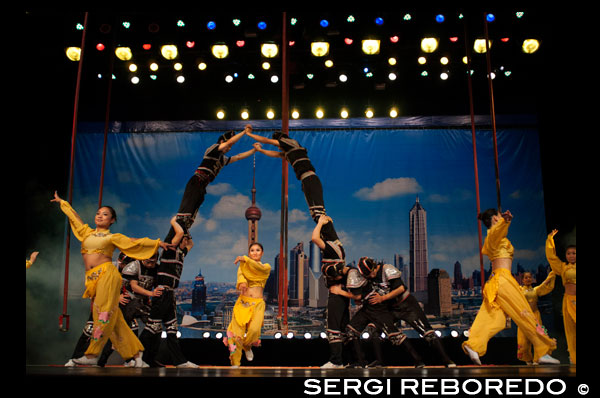 Shanghai Centre. Shanghai Zaji Tuan. Acrobat performance Shanghai Centre Shanghai China. Performance, Human pyramid Audience Stage Inside of a Shanghai troupe of magic and acrobatics, (Shanghai Shangcheng). Centre Theatre. Shanghai Acrobatic Troupe. Shanghai Acrobatic Troupe is the oldest acrobatic troupe in Shanghai and well known around the world. After animal acts were banned at the Shanghai Circus World, the troupe moved to the luxurious Shanghai Centre Theatre in 2005.  This experienced group has skillfully managed to bring together a show that has it all. While maintaining a traditional flavor, the performance is modern with extreme feats to keep you at the edge of your seat. The story is captivating and even the audience can take part!  The show and theater facilities are top-notch. No doubt this addictive spectacle is our first pick. The famous Shanghai Acrobatic Troupe has performed around the globe and is a wonderful night out for visitors to Shanghai. Their movement is art - tightly choreographed and rehearsed endlessly.  Where: The Shanghai Center Theatre, 1376 Nanjing Xi Lu, Shanghai, China When: 7:30pm, usually seven nights a week. Performed by the Shanghai Acrobatic Troupe, a well-known group of Chinese professional acrobats first founded in 1951, this electric show is a must-see in Shanghai.  You will get tickets to the Huangpu River Sensation, a production with strong Shanghai features, first presented by Shanghai Acrobatic Troupe in 2005 at Shanghai Center Theater.  The program consists of 3 parts: "Autumn Day," "Moon Reflection," and "Rosy Clouds," showing the vicissitudes of Shanghai; "Grand Feast," and "Lovers at the Bund," telling the story of yesterday; "Juggler in the Bar," reflecting the charm of today; and "Hoop Diving," and "Magic Illusion," predicting the development of tomorrow.  Some acts, such as “Play Dooly,” “Silk Stripes,” and “Pyramid of Chairs” were Gold Lion Award winners at the China National Acrobatic Competitions.  The full program is as follows:  Play Dooly Foot Juggling/Play Diabolo Glass Balancing Silk Rope Hanging Play The Ball Plate Spinning Small Teeterboard Nose Balancing Chair Balancing Straw Hat Pagoda of Bowls Skill in Handing Hoop Diving on The Table Large Springboard One-handed Handstand Modeling Soft Body Shake the Thick Stick 