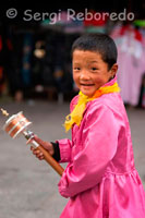 A Tibetan boy mill spins his prayer in the streets of Lhasa. Thousands of Tibetans debotos spin their prayer wheels, while doing the Kora around Kokhang and recite their prayers. Inside the mill there is a paper written with the prayer recited, so that when you spin once, as if reciting the prayer.