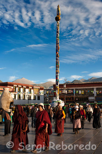 Monjes y peregrinos junto al templo Jokhang. Lhasa. Es imposible no dejarse arrastrar por la extraordinaria marea humana del Barkhor, que no es un monumentos, sino un kora que avanza en el sentido de las agujas del reloj alrededor del templo de Jokhang. Parece poseer una especie de gravedad mística y espiritual que atrae irremisiblemente a todo visitante que se acerque a menos de 50m , e incluso lo invita a repetir el circuito entero una vez más.