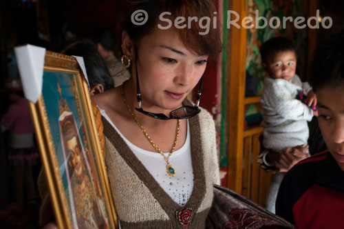 Una mujer con el cuadro de una deida sale del Monasterio de Tsepak Lhakhang. Lhasa. Las mujeres hacen procesión alrededor del templo para pedir al dios de la longevidad (Cherisi chepal) tener un buen parto, o personas ancianas para rezarle.