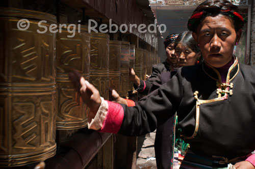 Several women spin the prayer wheels in Tsepak Lhakhang Monastery. Lhasa. Women make a procession around the temple to ask the god of longevity (Cherisi chepal) have a good birth, or elderly people to pray.