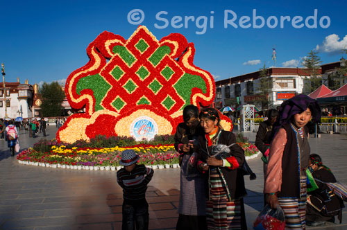 Plaza Barkhor con la conmemoración del 60 aniversario de ocupación de China en el Tibet. La Plaza está situada en la antigua zona de la ciudad de Lhasa, Tíbet, en la cual se ubica el fabuloso El Templo de Jokhang,Lhasa,Tibet. El pueblo tibetano siempre han estado muy orgullosos de ello. Es un símbolo de Lhasa y es un destino perfecto para todos los turistas. Hoy en día, incluso todavía hay muchos peregrinos que celebran la oración de ruedas.Caminan en sentido horario desde el amanecer a la oscuridad. También se pueden ver ha muchos peregrinos avanzando con sus propios cuerpos a lo largo de la calle.Incluso algunos de ellos son adolescentes y han recorrido muchos kilómetros a pie para llegar a este lugar sagrado.