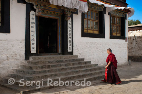 Un Monje budista en el interior del Monasterio Tashilumpo, ubicado en Shigatse, Tibet.  El Monasterio de Tashilumpo es el principal atractivo de Shigatse. Pueden verse a gran distancia los reflejos dorados de sus tejados. Aquí se encuentra la imponente estatua gigante de Buda, la más grande del mundo con 26,2 m. de altura, 11,5 de anchura y numerosas incrustaciones de joyas. El Monasterio de Sakya es conocido como el “Dunhuang tibetano” por su estilo mongol en estatuas, porcelanas, frescos, Tangkas (representaciones de Buda) y escrituras. El monasterio se hizo famoso en el siglo XIII, cuando Kublai Khan lo dotó de regalos, privilegios y control sobre todo el Tibet. Aquí se gestó una secta budista llamada Sakyapa.