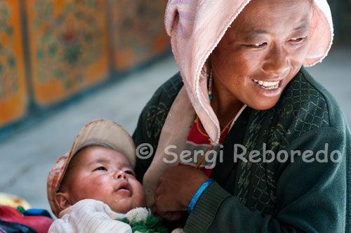 Portrait of a woman breastfeeding her child in the Tashilunpo Monastery, Monastery Tashilumpo, located in Shigatse, Tibet, is a reflection of Chinese culture and religion that has influenced people around the world. Visitors to the monastery are mostly Buddhist followers who want to honor and tribute to the sacred place. Others are simply curious about the lifestyle and the teachings of Buddhism. These beings visit the place to catch a glimpse of the rich and influential Buddhist tradition.