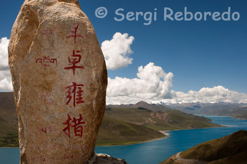 Lago Yamdrok visto desde el paso de Kamba La. Una piedra nos indica que estamos a 4441 metros sobre el nivel del mar. Los tibetanos consideran sagrados los lagos, al igual que las montañas, ya que son moradas de los dioses protectores y por ello están investidos con poderes espirituales especiales.Todos hacen peregrinaciones hasta sus orillas.