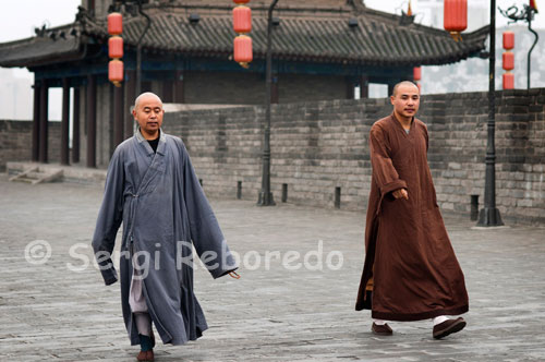 Monks walking down the top of the wall of Xi'an. Its shape is rectangular, about 12 meters high from the ground, and its width varies between 15 and 18 meters. There are several escape routes in addition to the four main gates are located in each of the cardinal points.