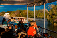 Cruise along the Victoria Falls aboard the " African Queen".  Sunset cruises on the Zambezi River at Victoria falls watch hippo pods & elephants sometimes crossing the Zambezi. Guests are collected from their hotel or lodge at 15:30 in winter and 16:00 hrs in the summer months and transferred to the jetty site. Cruise departures at 16:00 hrs in winter and 16:30 in summer. Following this sunset cruise, you will be transferred back to your hotel between 18:30 hrs and 19:00 hrs (winter and summer respectively). At the jetty side guests are met by a Traditional African Band before signing the standard Indemnity Form. After a safety briefing and talk guests board the safari boat. Heading off downstream, meandering through the islands, the guides will talk to you and describe the flora and fauna as well as the prolific bird life and wildlife. 