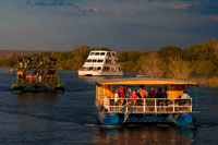 Cruise along the Victoria Falls aboard the " African Queen".  Other boats sailing in the Zambezi River. Take a Sunset Cruise down the mighty Zambezi River. This Sundowner Cruise takes you down the Zambezi River for a beautiful journey!. The Zambezi Sunset River cruise is a superb way to relax and enjoy the beauty of the River. You may have the opportunity to see a variety of game; including hippo, crocodile, elephant and sometimes even rhino in their home environment, as well as enjoy the many different bird species. 
