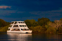 Cruise along the Victoria Falls aboard the " African Queen".  Other boats sailing in the Zambezi River. This is the “Lady Livingstone” boat.  The newly built lady Livingstone famously known as "The Jewel of the Zambezi" has a capacity of 144 pax. Guests are met at their respective hotels/Lodges and transferred to the David Livingstone safari Lodge and Spa. The cruise takes place along the river boundary of the Mosi-Oa-Tunya National Park, total cruise time is approximately 2 hours. During the cruise, clients are likely to see hippos, crocodile and some good birdlife. Possible other game sightings are elephant, giraffe, buffalo and buck. An experienced guide accompanies each cruise and has good knowledge on the wildlife and local history of the area.  Excellent hot and cold snacks are served on board and the bar is well stocked with spirits, good wines, beers and soft drinks. Snacks and drinks are included in the price and served throughout the cruise.  Pick up times are 16h00 in summer (August to April) and 15h30 in winter (May to July).  