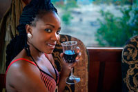 Black woman traveling in the Livingstone Express luxury train drinking wine. The Royal Livingstone Express offers the discerning guests the ultimate fine dining experience going back in time to the age of steam train travel. Luxury steam train dining as you travel on the historic Mulobezi Railway line, formerly one of the largest private rail networks in the world. The train itself consists of 5 carriages restored by Rohan Vos of Rovos Rail and pulled by either Locomotive 156 or Locomotive 204 and is fully air conditioned. Fulfil your romantic fantasy, escape on a late afternoon train journey amidst the untamed natural Zambia bushveld. Sun International is proud to announce the inauguration of the Royal Livingstone Express, a joint venture between Sun International and Bushtracks Africa. 