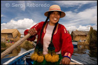 Altiplà Peruà Una dona vestida amb vestits típics regionals navega amb la seva barca entre les illes dels Uros.