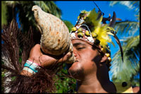POLYNESIA. COOK ISLAND. Aitutaki. Cook Island. Polynesia. South Pacific Ocean. An actor dressed Polynesian blowing a conch shell in Aitutaki Punarei Culture Tours. This is a unique opportunity for you to learn about the ancient culture, myths, legends and traditional ways of our ancestors. The tour is a great way to discover the history, traditional skills, Art & beliefs of the island of Aitutaki. The tour concludes with a traditional feast (umu kai) for lunch on site. The second voyagers of note were Te Erui and his brother Matareka. Te Erui set out from Havaiki in the canoe Viripo, An unexpected hurricane, hur1'hia, dismasted his vessel, but he managed to get back to Havaiki. On being told by a priest that the cause of the disaster was due to the naming of his canoe, he immediately built another canoe. The vessel, on the advice of the priest, was named Te Rangi-pae-uta, and the two masts were named after the gods Rongo and Tangaroa. Thus, with divinity sitting in the belly of his sail, he braved the sea once more in his quest of land. He landed on the West side of Aitutaki, at a point on the reef known as Te Rua-karae. Here he was opposed by one of Ru's descendants, who said, "Tera te moana uriuri o Hiro. Haere ki i'eira kimi henua ai " – "There lies the purple sea of Hiro. Go there to.seek land." The request went unheeded. After slaying various opponents, Te Erui cut a channel through the reef with his adze, Haumapu, and finally settled down at Reureu. The channel which is credited to Te Erui's engineering ability is Te Rua-i-kakau, the boat passage which has been such an inestimable boon to Aitutaki. The various historical spots mentioned are shown on the map of Aitutaki. Ruatapu, the third voyager of note, came from Taputapuatea to Rarotonga, and then successively to Raro-ki-tonga, Mauke, and Atiu. During these voyages his canoe had the name of Te Kareroa-i-tai. At Atiu, the canoe name was changed to Tuehu-moana, and in it he sailed to Manuae and then Aitutaki. At Aitutaki he sailed through a passage near the north end, called Kopua-honu, and re- named, after him, Kopu-o-Ruatapu. He is credited with having brought the coconut and the flowering plant known as tiare maori. After quarrelling with his son Kirikava over fishing nets, he came on to Ruatea, near Black Rock. From there he attracted the attention of the ariki Tarula by means of certain toys, and they became friends. He excited the curiosity of Taruia with tales of the islands he had visited, and finally persuaded the ariki to accompany' him on a voyage to see the beautiful women of the islands (nga wahine purotu o nga motu.) Ruatapu purposely sailed before Taruia was quite ready, and to the latter's appeal to wait he called back, " I will go on to Rarotonga and be on the beach to welcome you in." On the other side of the islet of Maina, at a spot called Rau-kuru-aka, Ruatapu purposely capsized his canoe. Taruia shortly afterwards appeared, and to Ruatapu's appeal to wait until he had righted his canoe, he replied with no small satisfaction, "No; I will go to Rarotonga and be on the beach to welcome you in."Ruatapu waited until Taruia was out of sight. He then righted his canoe and, returning to Aitutaki, he had himself made Ariki of the island. Ruatapu is a well-known Maori ancestor of similar parentage,with whom a canoe-sinking incident is also associated in tradition.