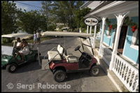 Golf cars parked outside a tax-free shop. Dunmore Town - Harbor Island, Eleuthera.