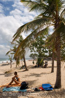 Kuta Beach. While some tourists decide to surf other resting on the sand. Bali. Indonesia. Asia.