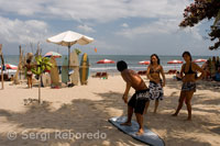 Kuta Beach. While some tourists surf pratica other classes in the sand. Bali.