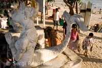 A statue at the entrance to the beach. At dusk everyone gathers to watch the sunset, taking a beer on the beach of Kuta. Bali.