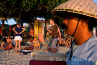 At dusk everyone gathers to watch the sunset on the beach of Kuta. Bali.