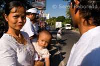 A family at the exit of a Hindu temple during the celebration of a feast. Bali.