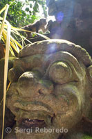 The monkeys are having fun on the stone statues of the Hindu Holy Book Forest Monkeys. Ubud. Bali. Indonesia.