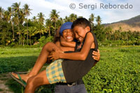 Two young men have fun in a field of crops near the fishing village of Amed East Bali.