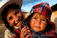 Unas niñas en la isla de Los Uros vestidas con su traje típico regional a los pies del Lago Titicaca.